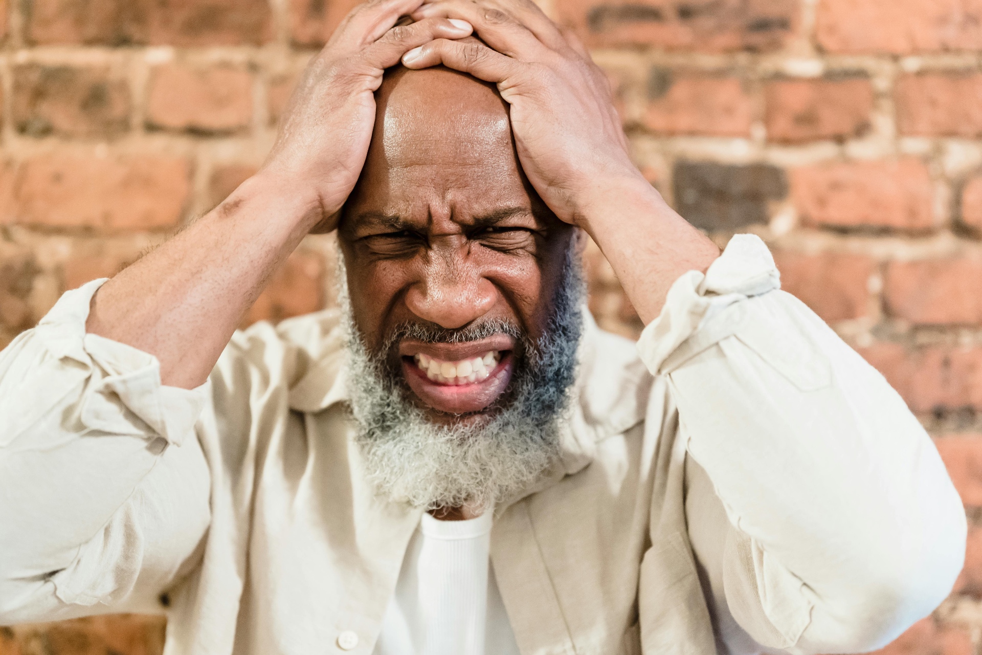 An African American man pausing with a cup of tea in soft window light